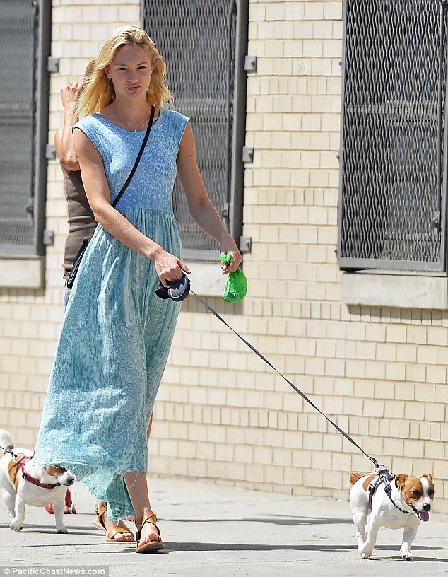 Candice Swanepoel covers up for a walk with the dog